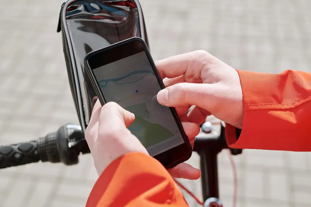 Cycliste utilisant une application GPS vélo sur smartphone