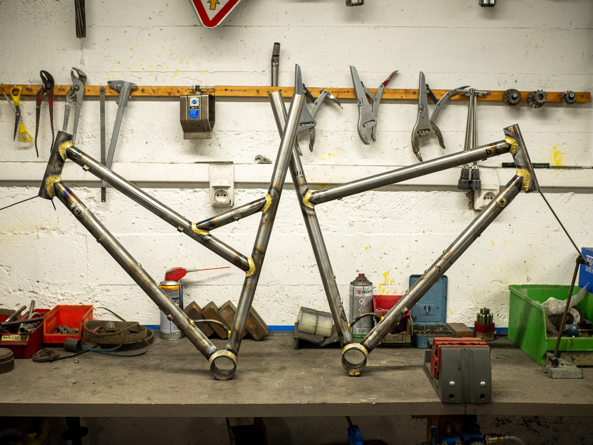 Deux cadres de vélo en cours de fabrication posés sur l'établi de l'atelier Cycles Cattin